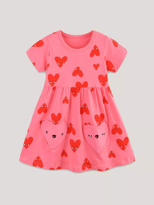 Pink cotton baby dress with red heart print and heart-shaped pockets.