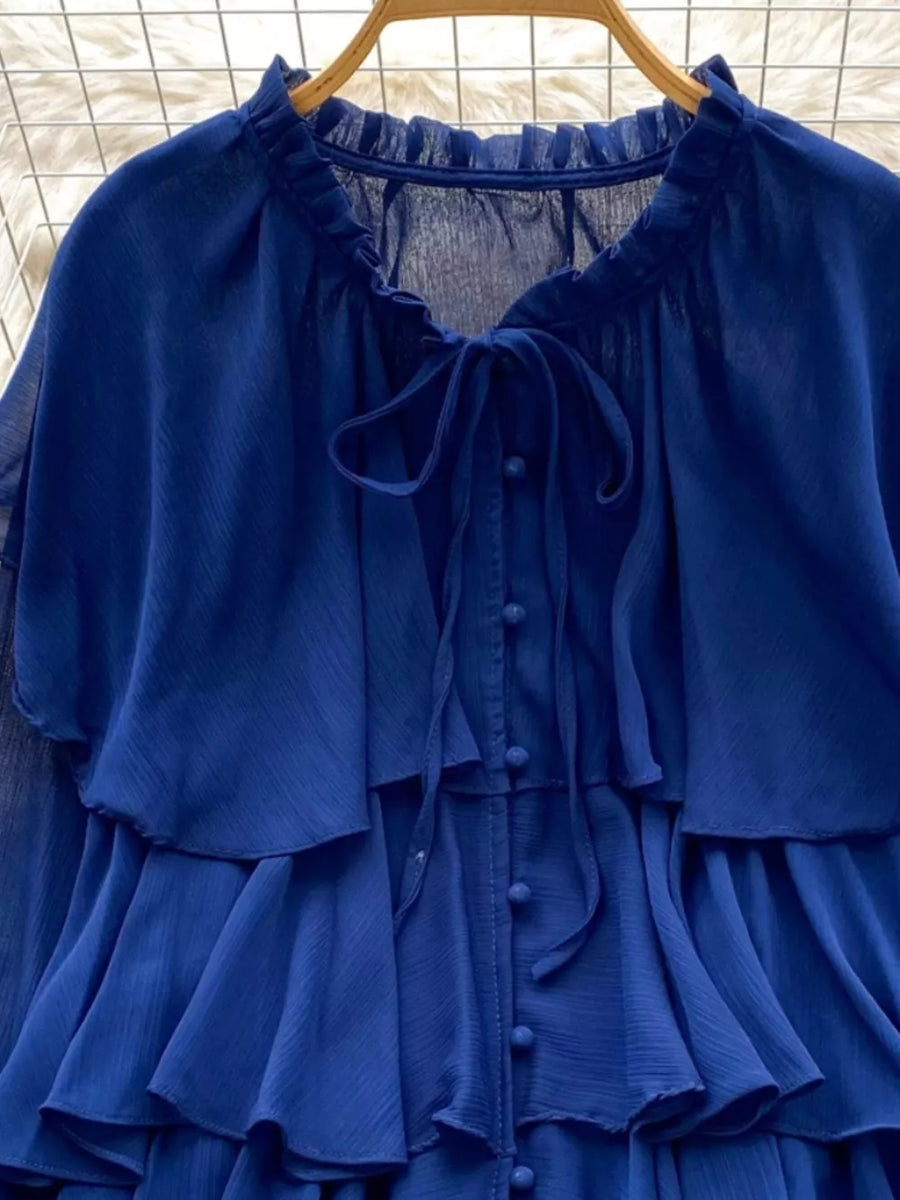 Blue chiffon tiered blouse with ruffled details and bow tie neckline.