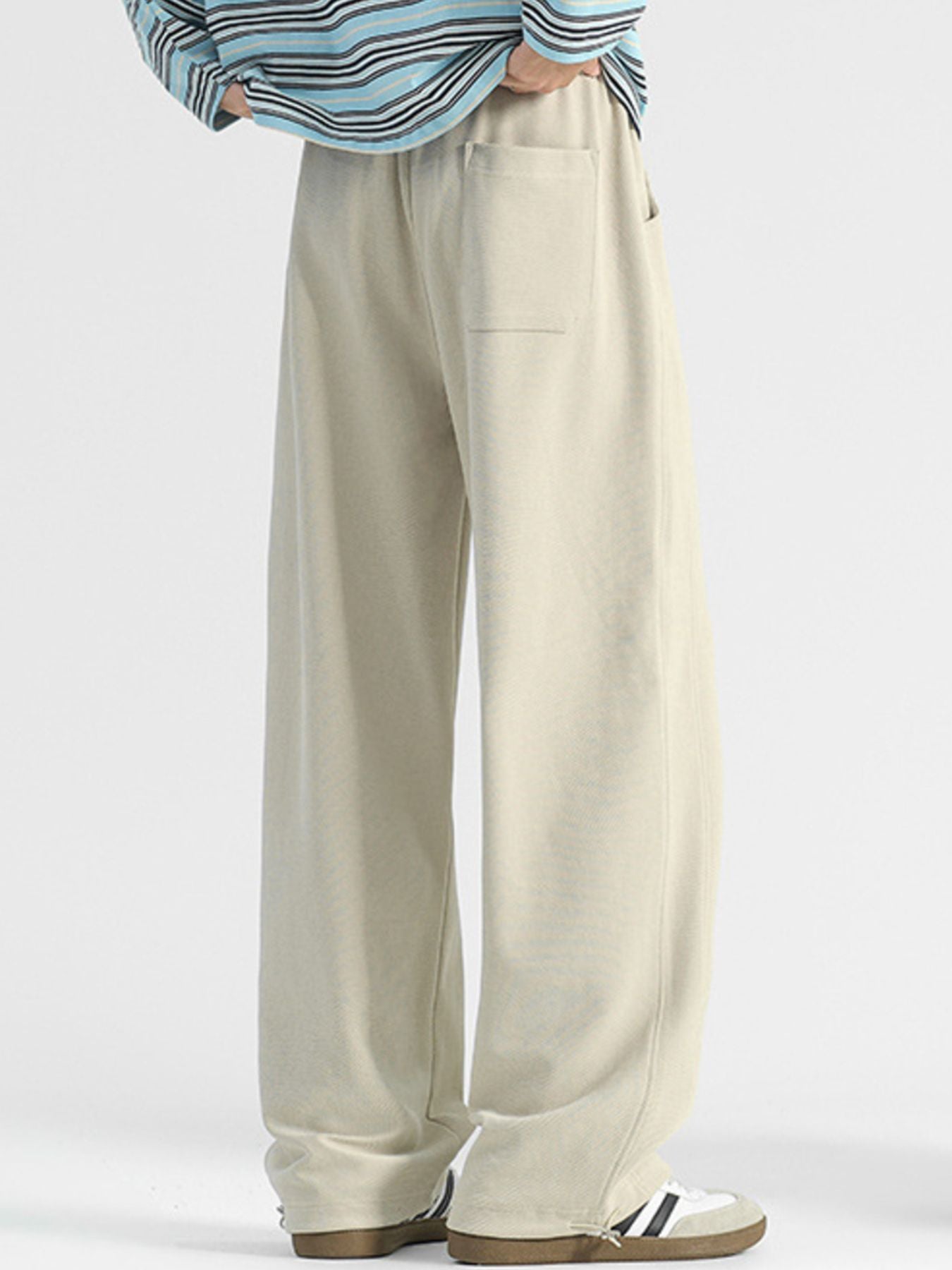 Men's beige casual loose-fit drawstring pants with pockets.