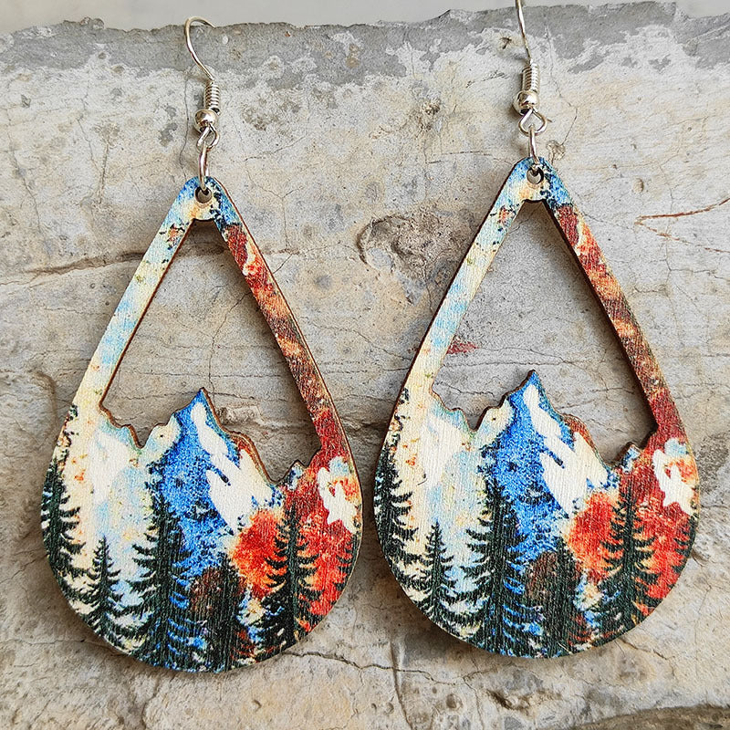 Teardrop silhouette earrings with mountain and forest scene, boho style.