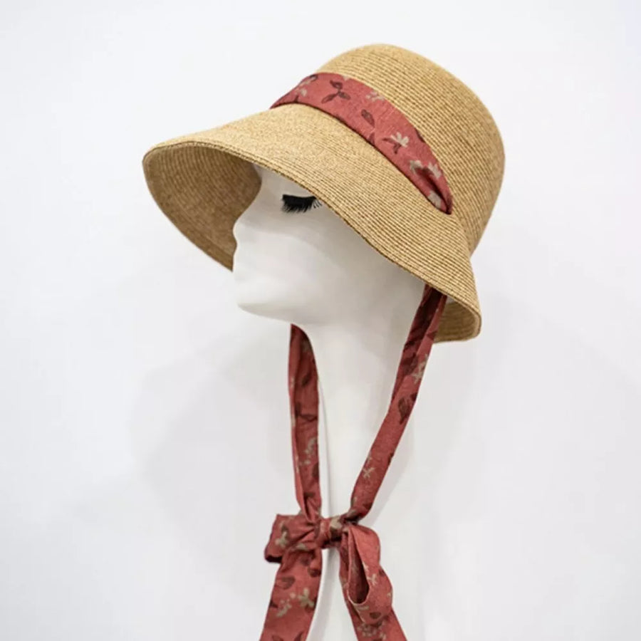 Straw sun hat with red floral ribbon and tie, defined crown