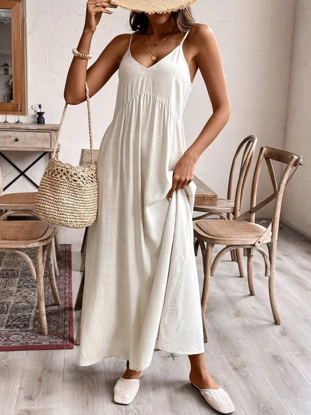 Effortless V-neck maxi dress in cream with spaghetti straps and a flowing skirt.