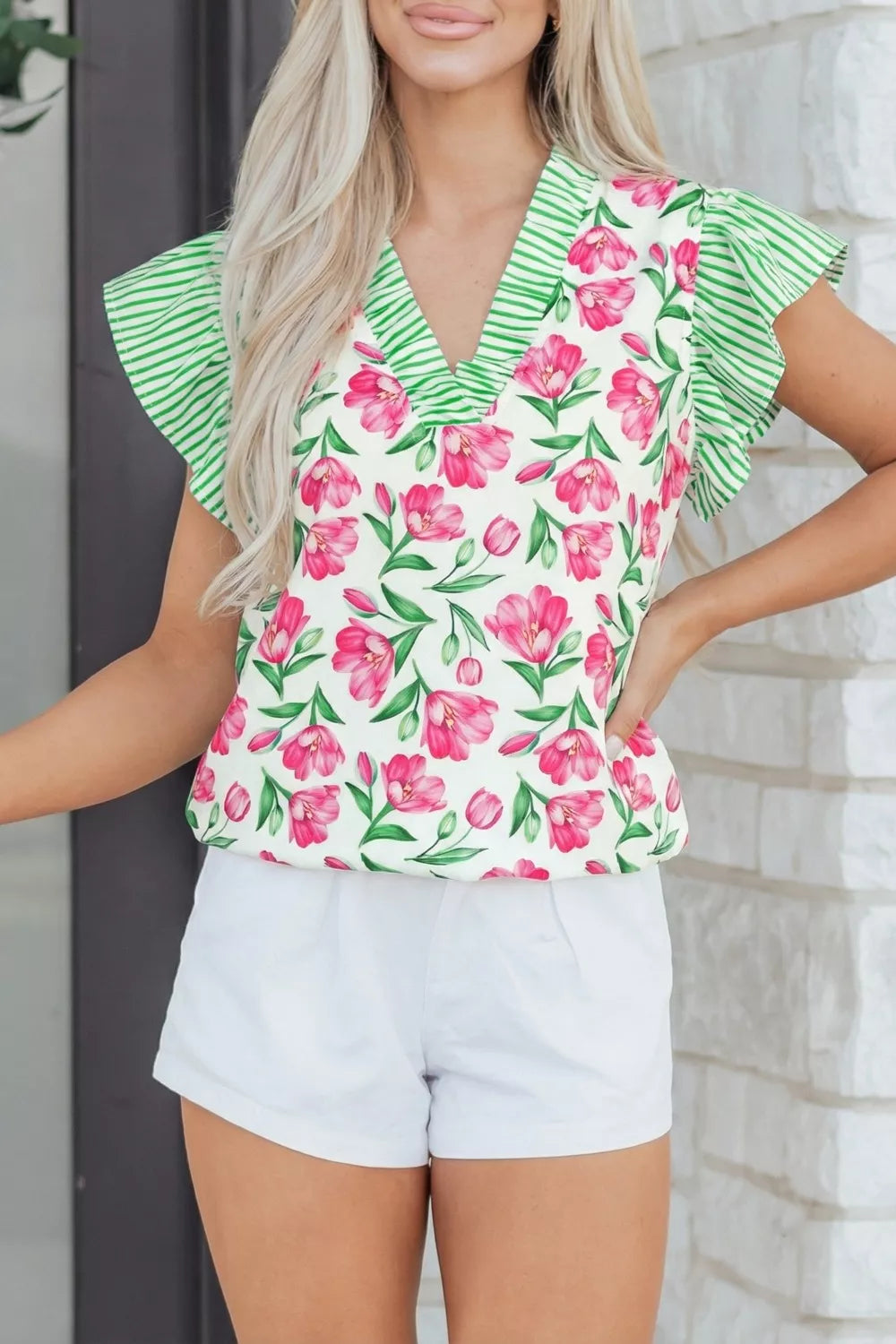 Tulip print ruffled V-neck blouse with green striped trim and flutter sleeves.