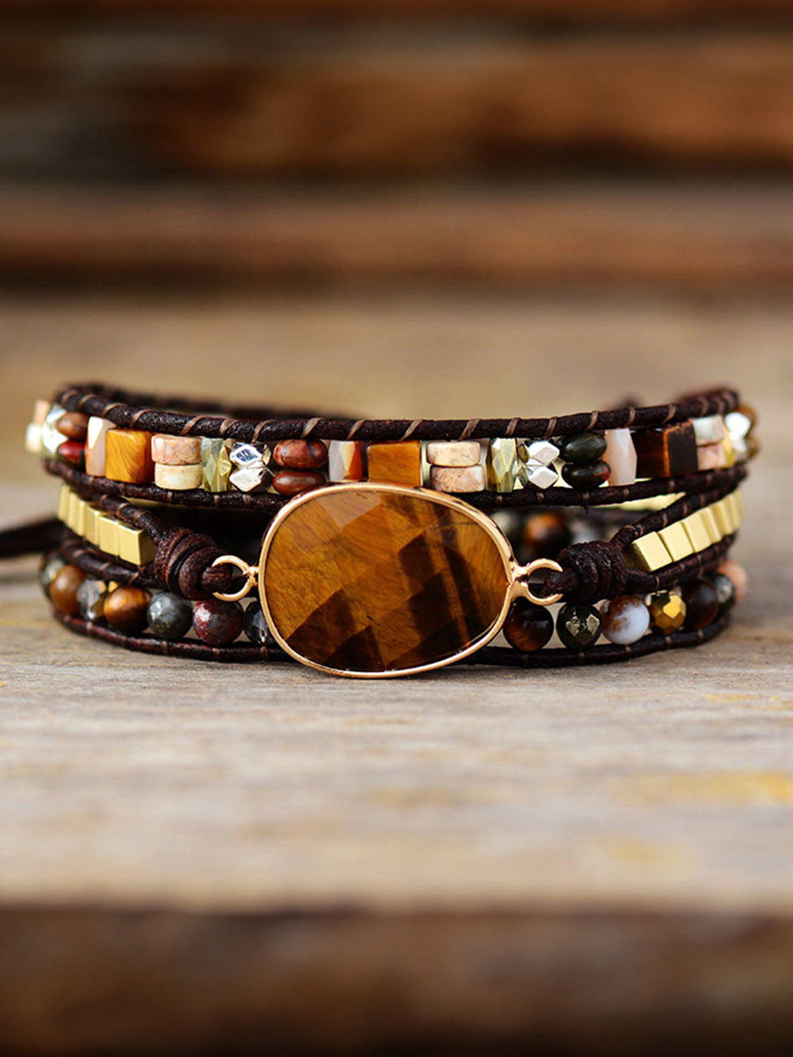 Wrap-around bracelet with tiger's eye stone, beads, and gold accents on leather cord