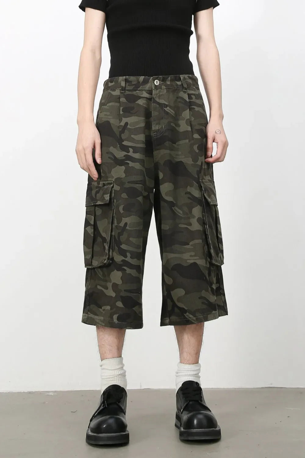 Green camouflage pleated culotte cargo shorts with buttoned flap pockets.