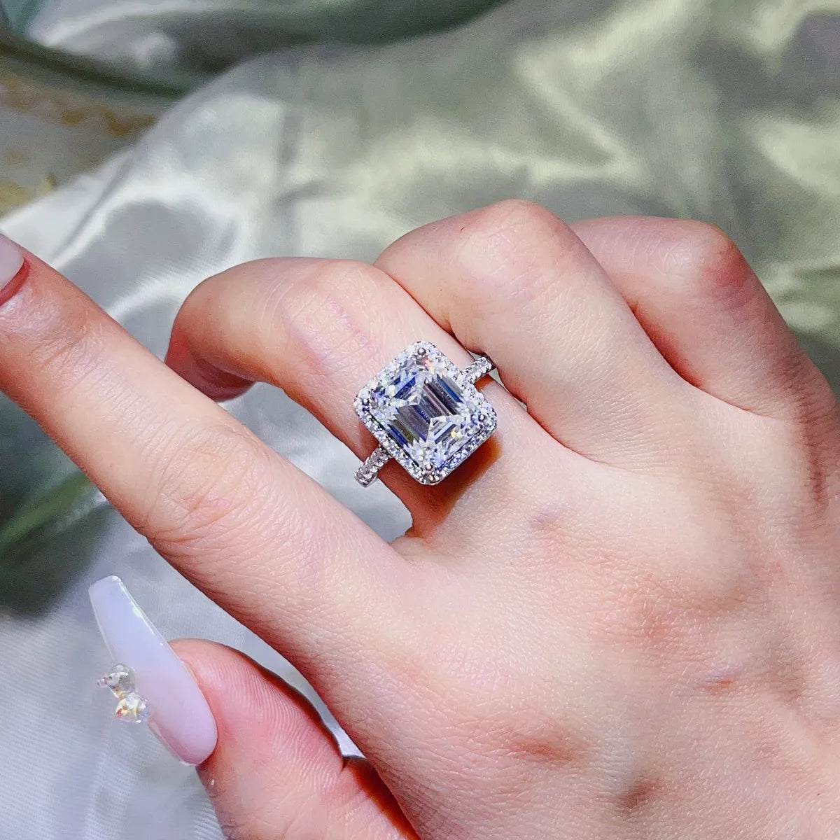 Emerald cut moissanite halo ring in sterling silver.