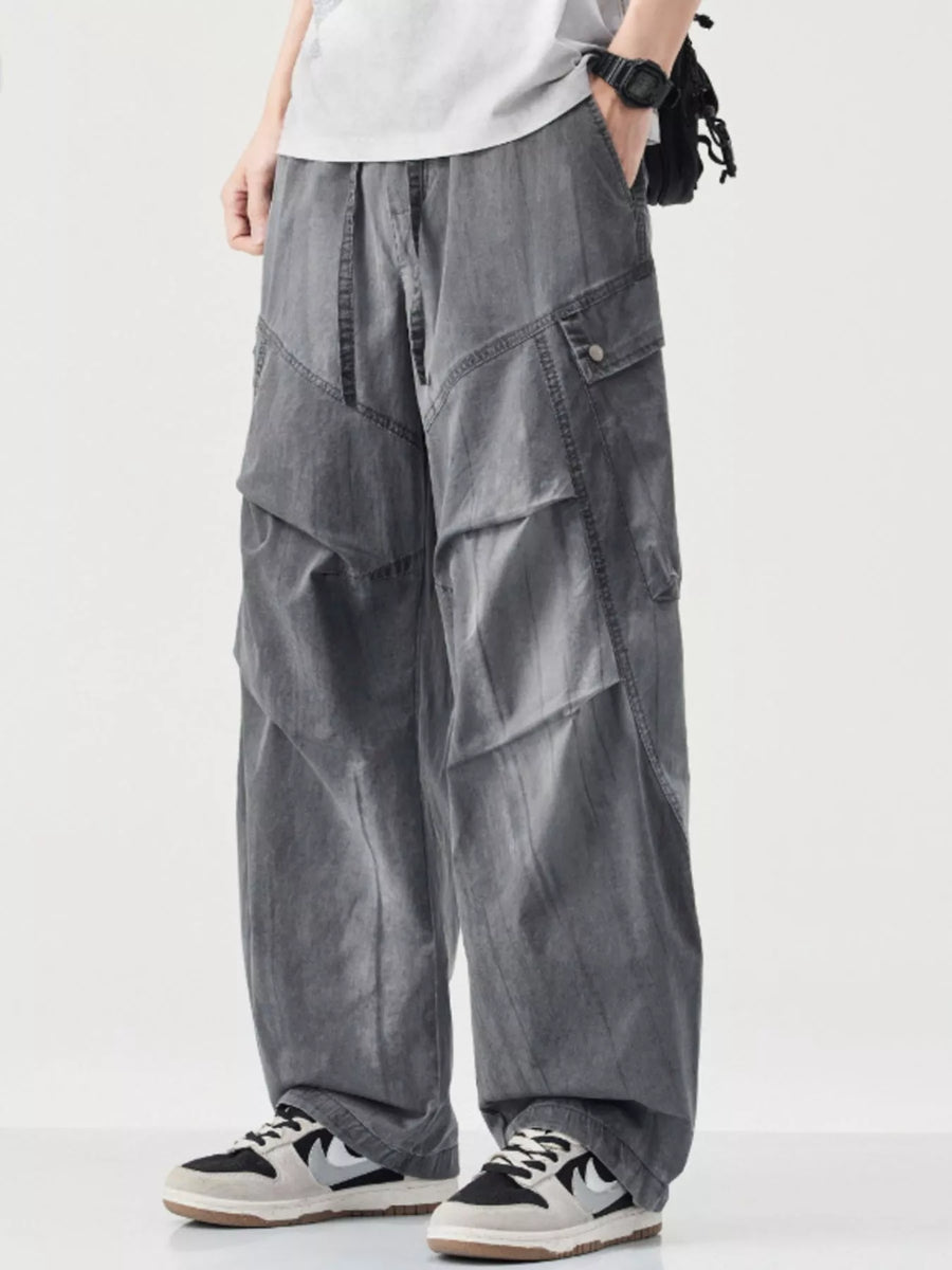 Loose fit grey cargo pants with drawstring and multiple pockets.