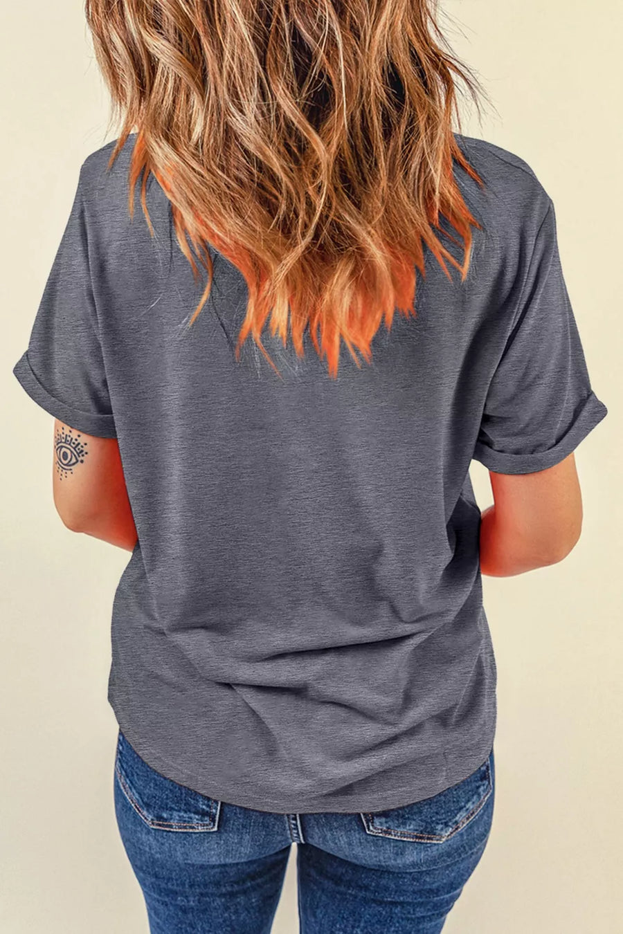 Gray polyester t-shirt with rolled short sleeves and a graphic print detail on the back.