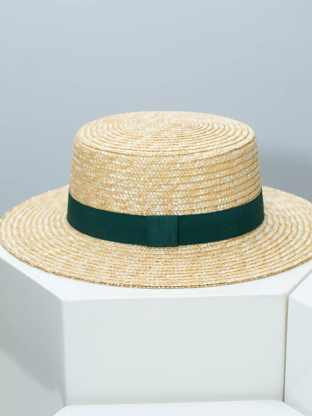 Women's straw boater hat with dark green ribbon band
