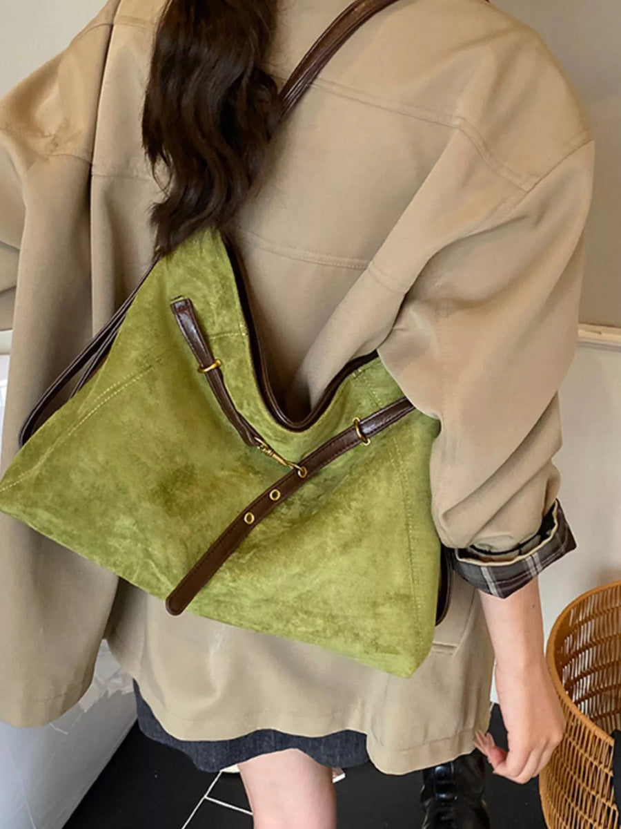Green suede large tote bag with brown leather trim and adjustable strap details.
