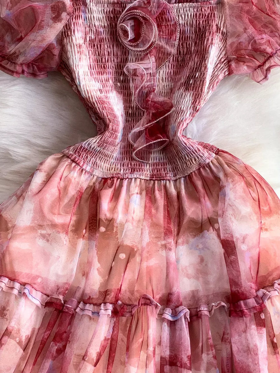 Floral midi dress with smocked bodice and ruffled trim in a pink watercolor print.