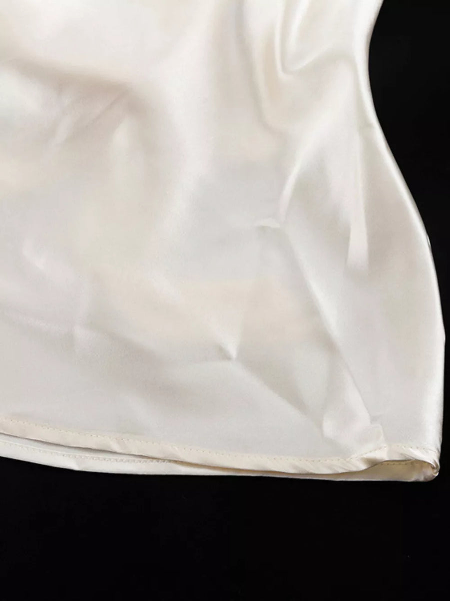 Cream satin camisole with a subtle sheen and a finished hem.
