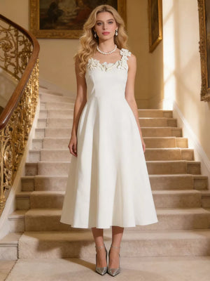 White sleeveless midi dress with floral neckline detail and full skirt.