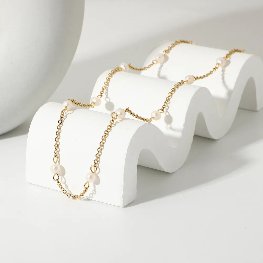 Delicate gold chain necklace with small pearls, perfect for women.