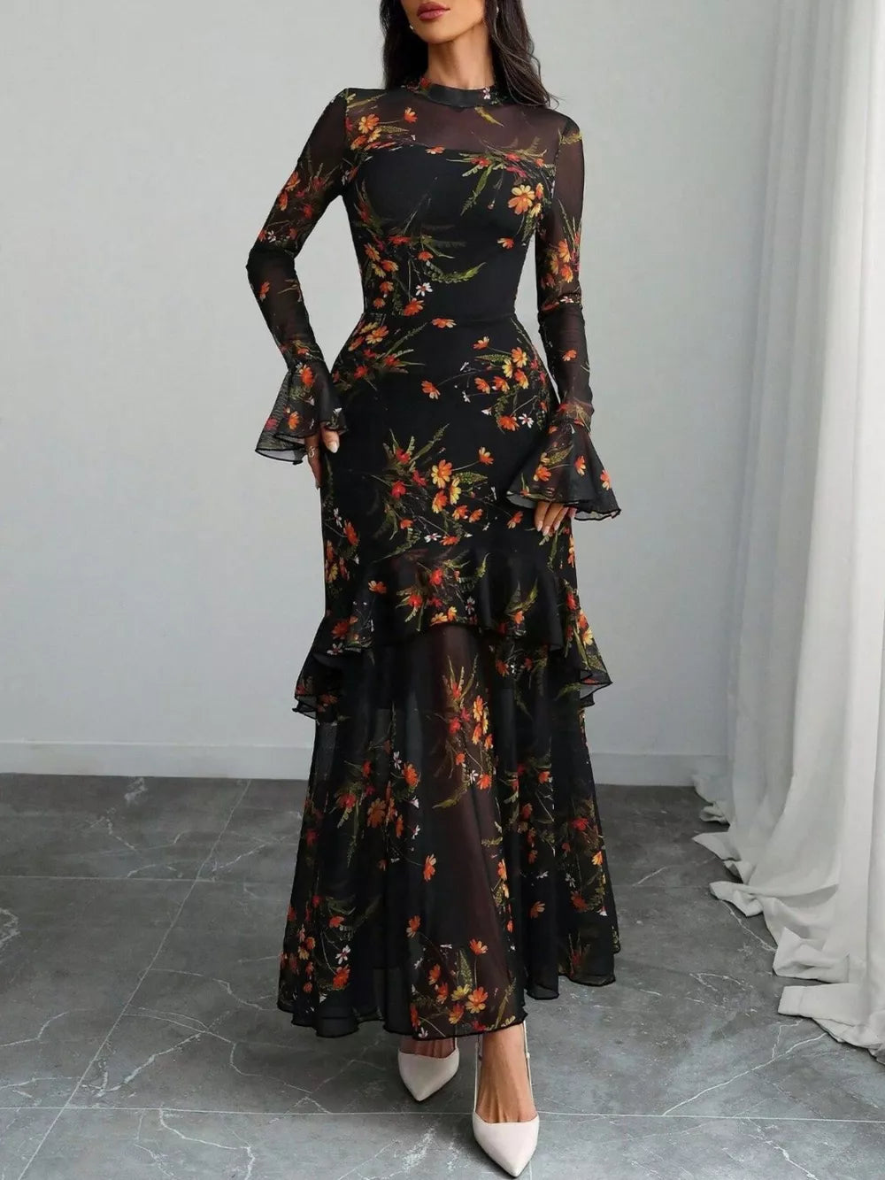Black floral mermaid maxi dress with sheer flounce sleeves and tiered skirt.