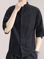 Black cotton button-down shirt with roll-up sleeves and chest pocket.