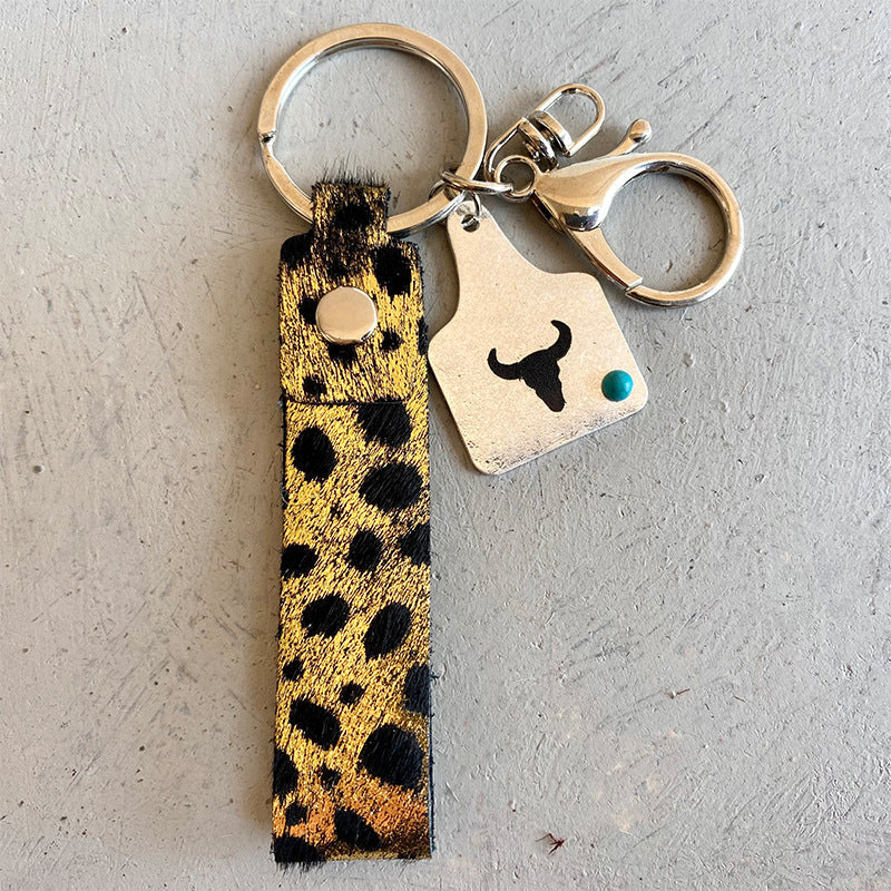 Cheetah print leather keychain fob with bull tag charm and turquoise accent.