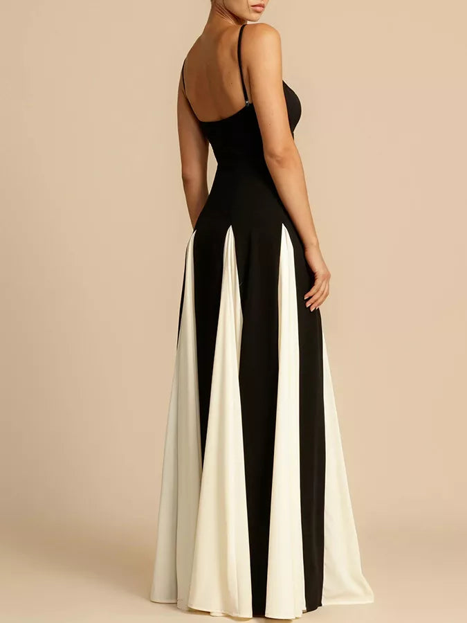 Elegant black and white maxi dress with spaghetti straps and pleated skirt detail.