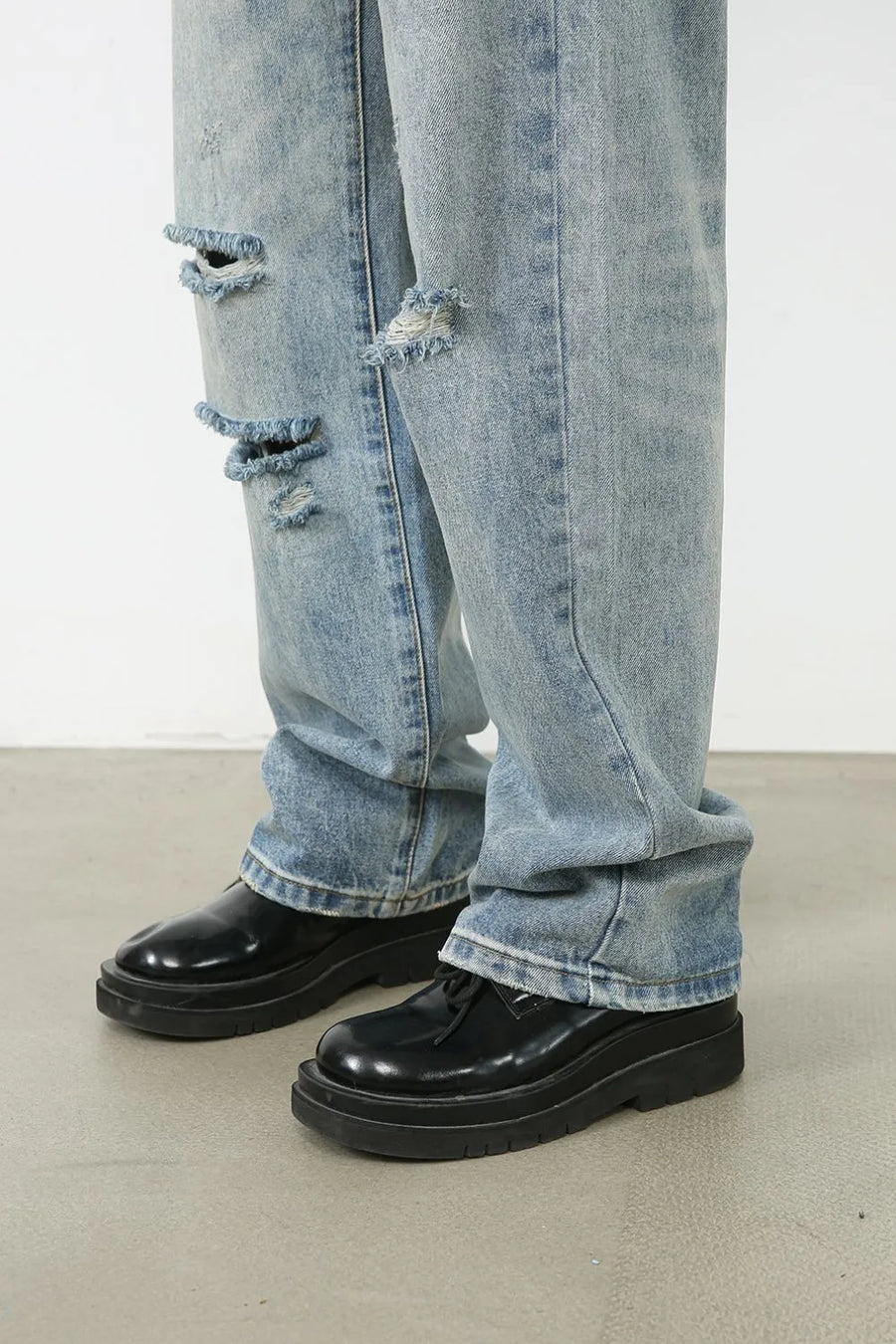 Baggy ripped denim jeans in medium wash with distressed details and a casual fit.