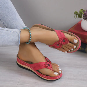 Petals & Post sandals in strawberry pink with floral embellishments and white-painted toenails.