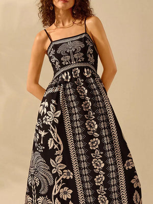 Black floral print spaghetti strap maxi dress with a-line cut and bohemian details.