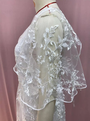 White lace flutter sleeve dress with floral embroidery detail.