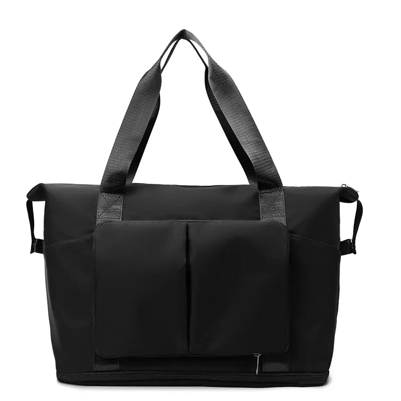 Black foldable travel tote with dual exterior pockets and dual top handles