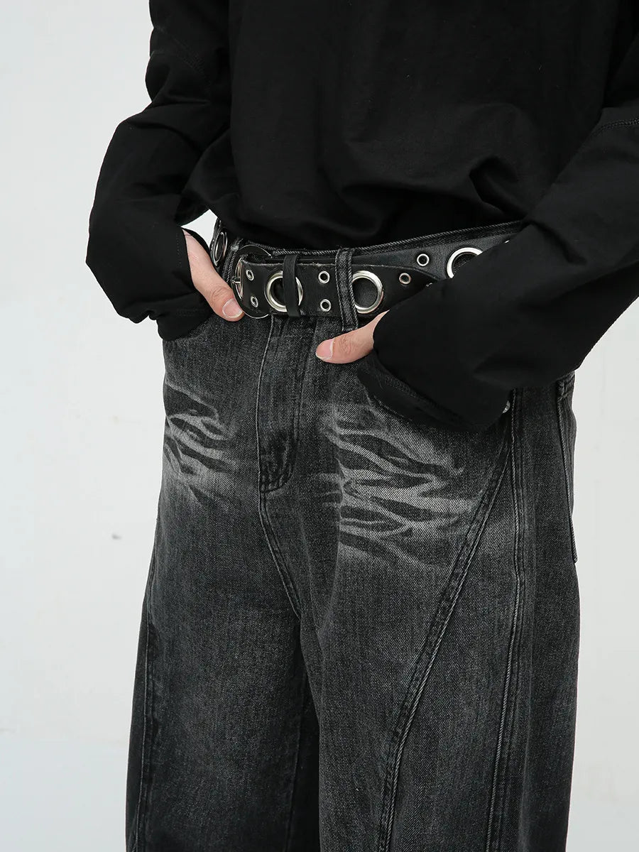 Faded panel wide-leg jeans in dark wash denim with a distressed pattern and a grommet belt.