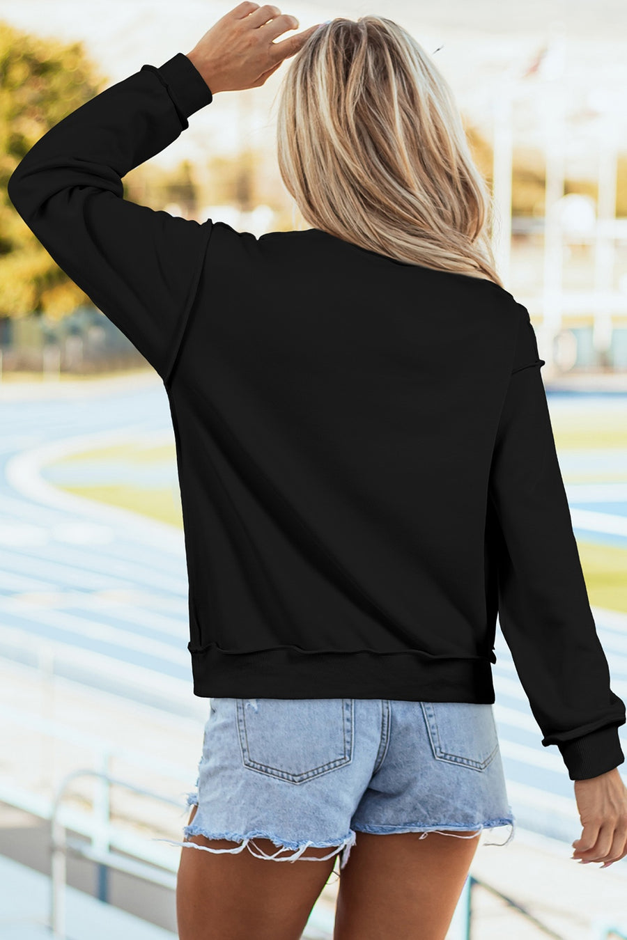 Black sweatshirt featuring rhinestone embellishment and graphic-print