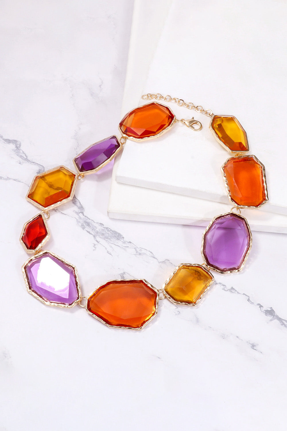 Prismatic resin stone collar necklace with multicolor faceted gems and gold chain.