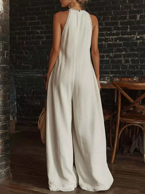 White linen halter jumpsuit with wide legs and lace trim detail