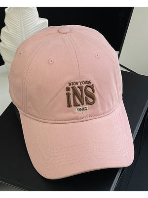 Pink baseball cap with embroidered New York INS 1982 detail