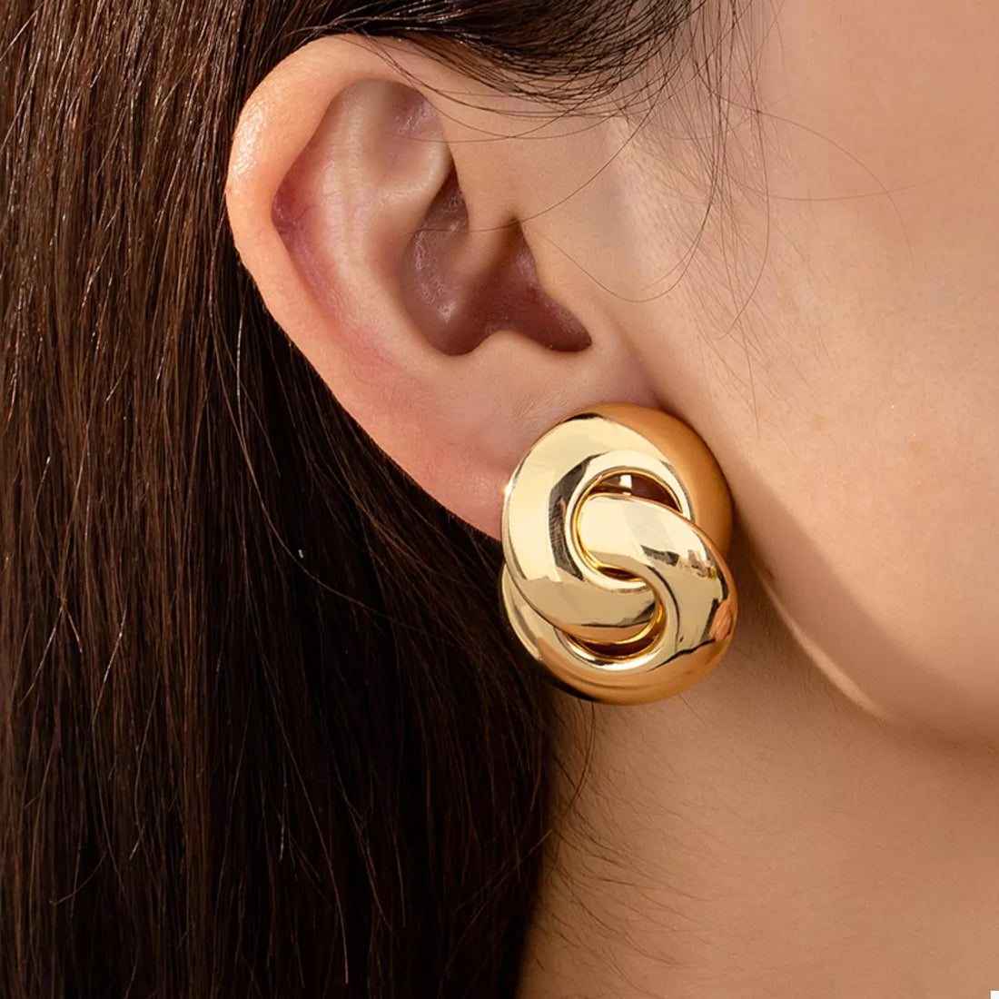 Chunky knot gold-plated earrings with interlocking loops.