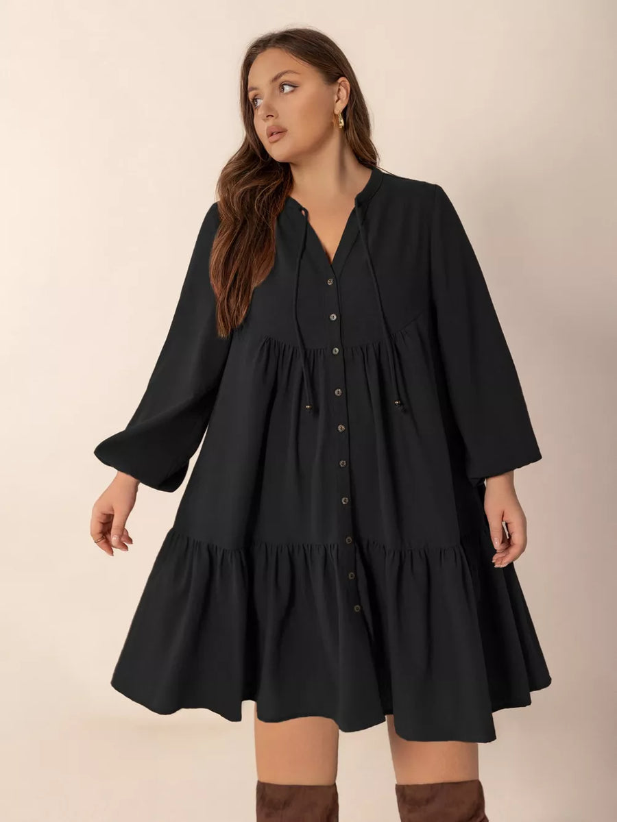 Plus-size black tiered button-front dress with balloon sleeves and tie neck