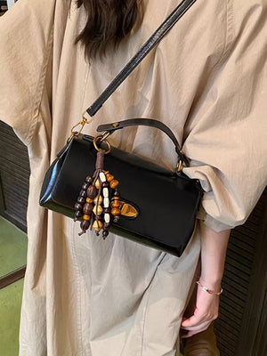 Compact black pu leather shoulder bag with beaded tassel detail and gold hardware