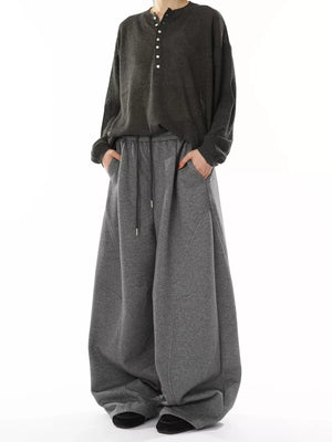 Men's gray wide-leg sweatpants with drawstring waist and pockets.