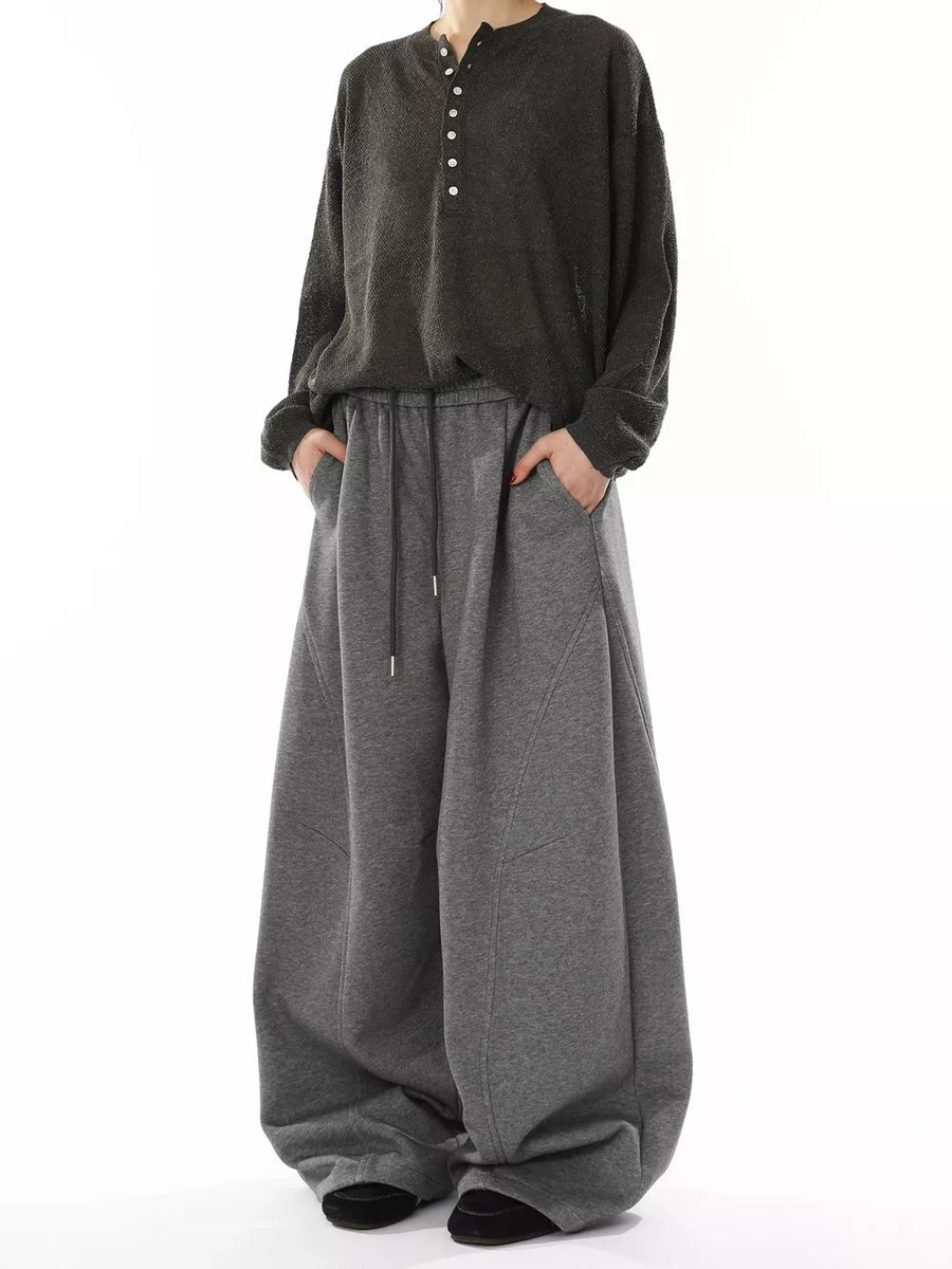 Men's gray wide-leg sweatpants with drawstring waist and pockets.