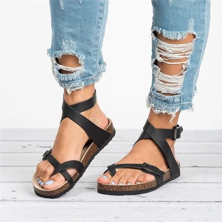 Black crisscross strap cork footbed sandals with ankle strap and buckle detail.