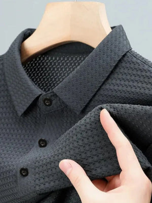 Dark gray textured pique polo shirt with refined collar and button placket detail.