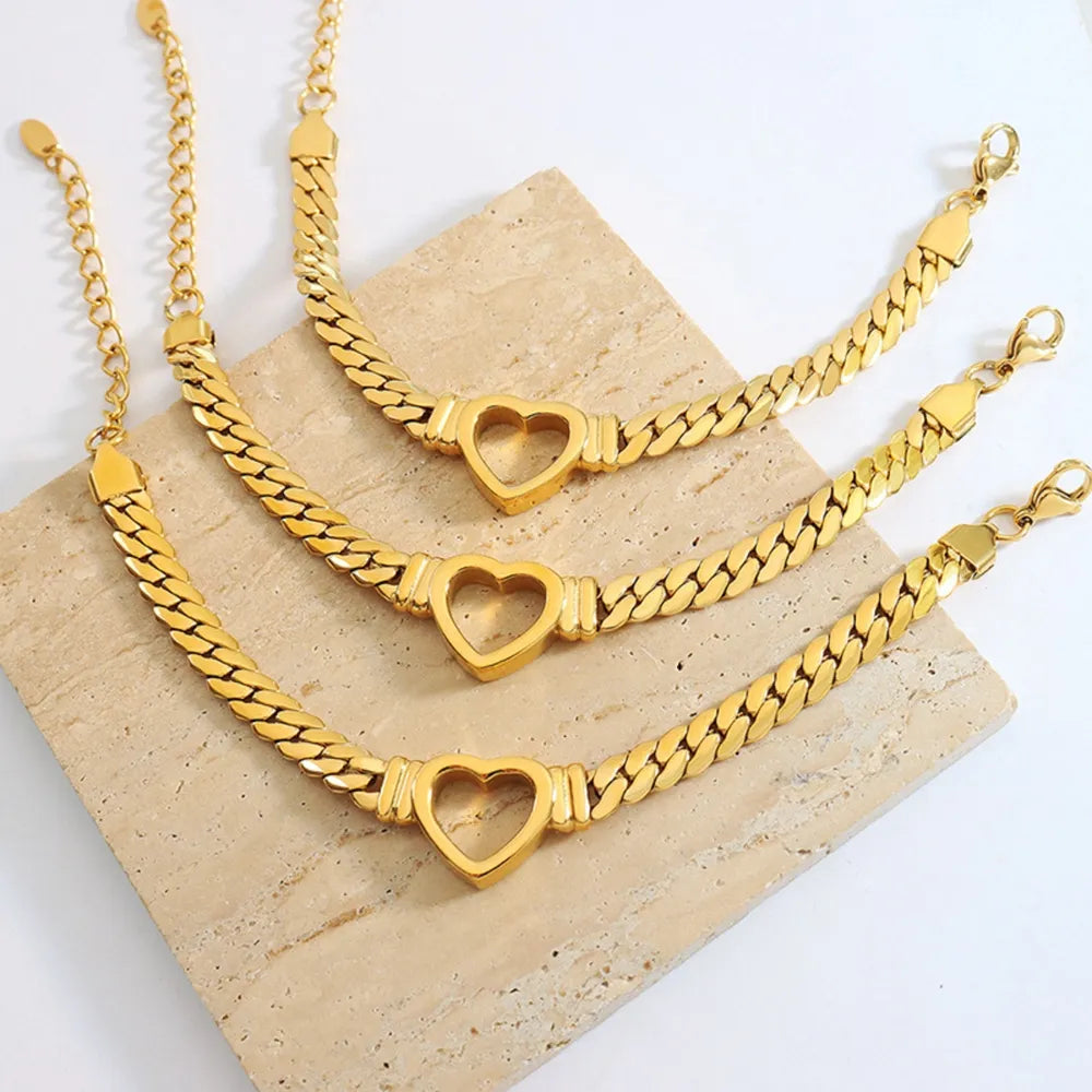 Gold curb chain bracelet with heart link detail, 18K gold-plated