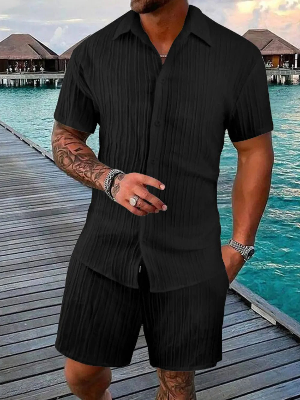 Black textured pleated resort shirt and shorts set with short sleeves and a buttoned front.