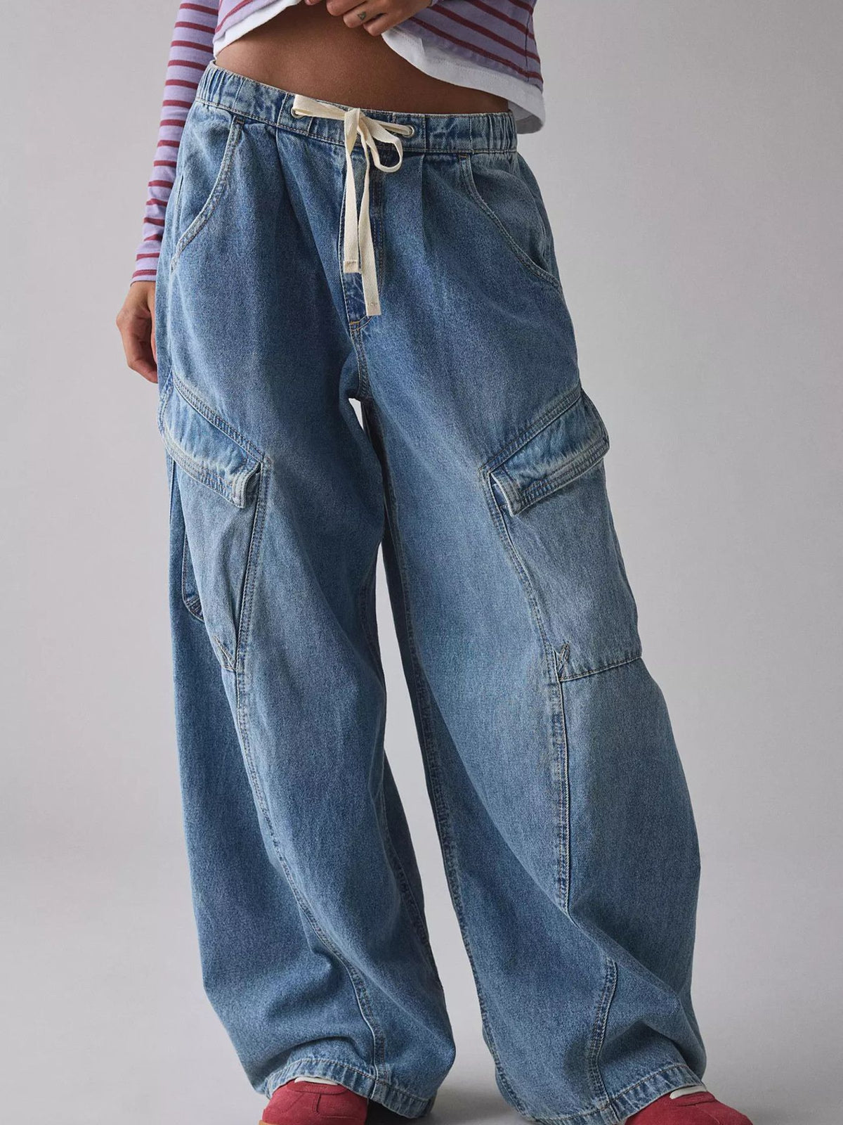 Dusty blue denim cargo jeans with drawstring waist and large side pockets.