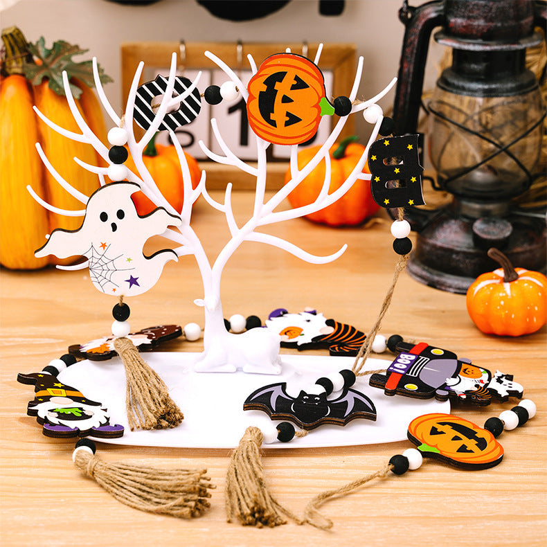 Halloween garland with ghost, pumpkin, bat, and gnome charms on a white tree display.