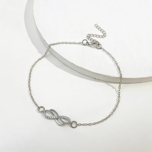 Silver infinity knot charm bracelet with adjustable chain and cubic zirconia accents