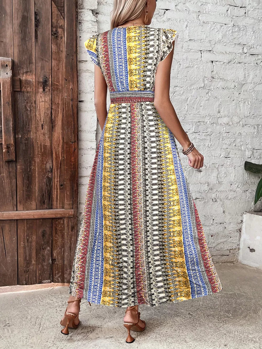 Bohemian maxi dress with ruffle sleeves and a vibrant geometric print in yellow, blue, and brick red.