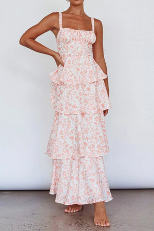 Tiered maxi dress with spaghetti straps, square neckline, and a white floral print with pink accents.
