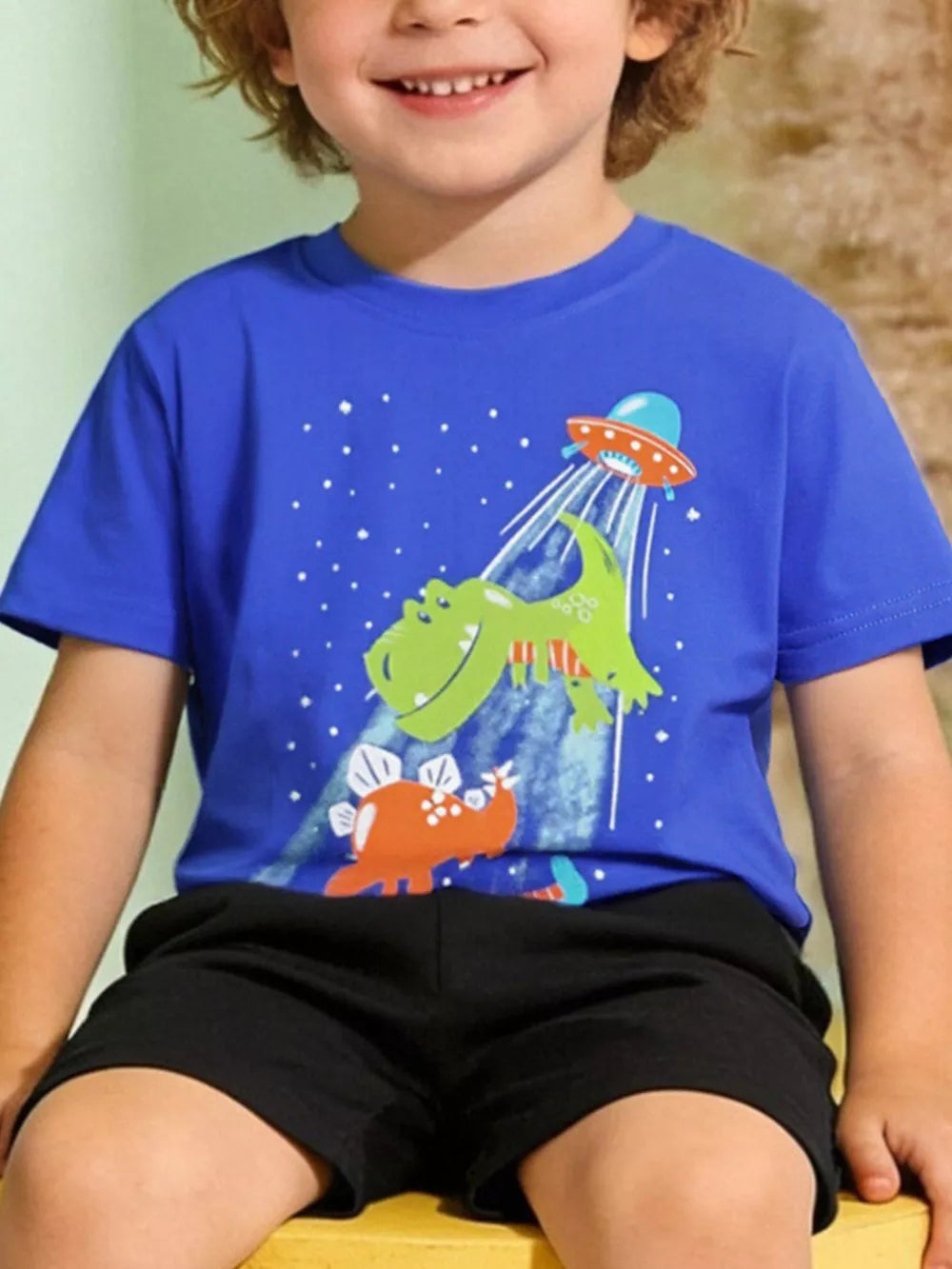Playful dinosaur and UFO graphic t-shirt for kids.