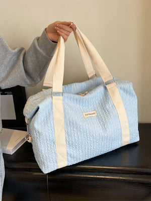 Pastel blue waffle-weave weekend bag with cream straps and silver hardware