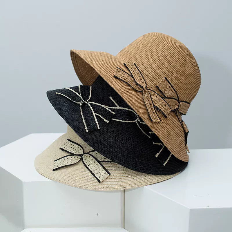 Chic straw sun hats in black, khaki, and beige, each with a decorative bowknot detail.