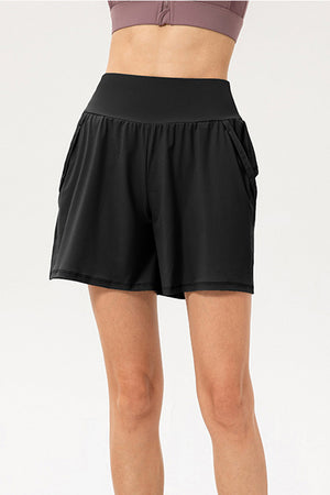 Black active layered pocket shorts with a high waistband and side pockets.